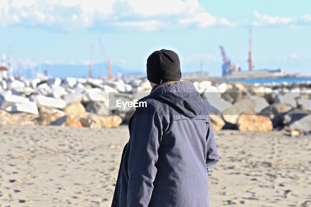 Man standing at beach against sky