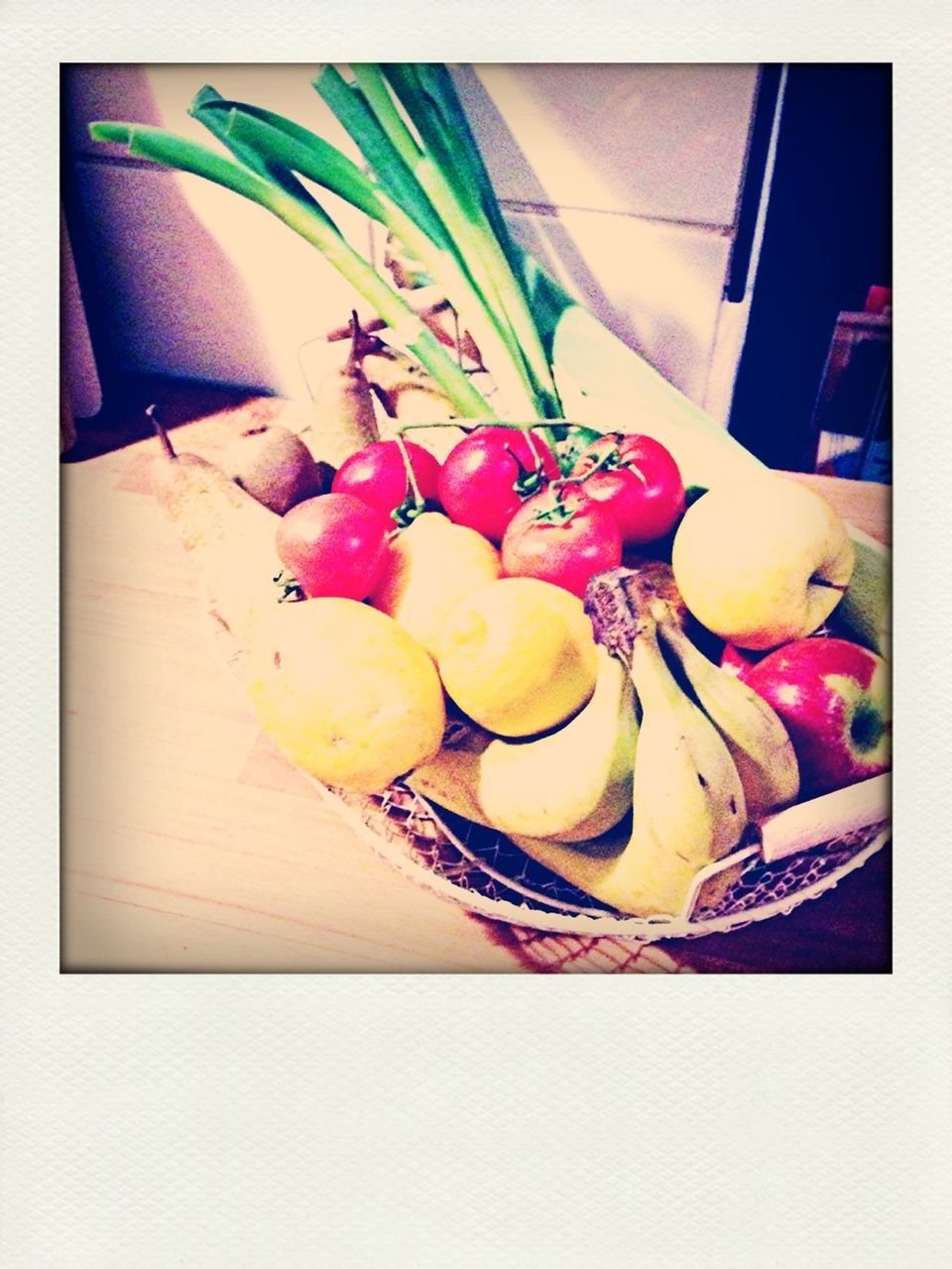 Fresh fruits and vegetables in basket on table