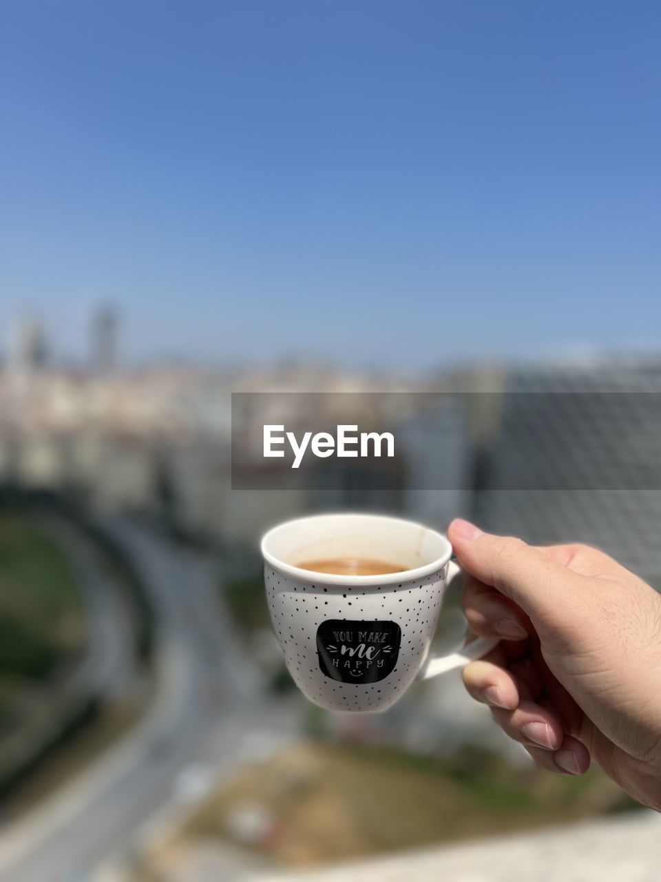 hand, drink, cup, one person, holding, coffee, food and drink, refreshment, mug, architecture, coffee cup, focus on foreground, city, sky, adult, day, copy space, clear sky, built structure, building exterior, close-up, nature, outdoors, hot drink, lifestyles