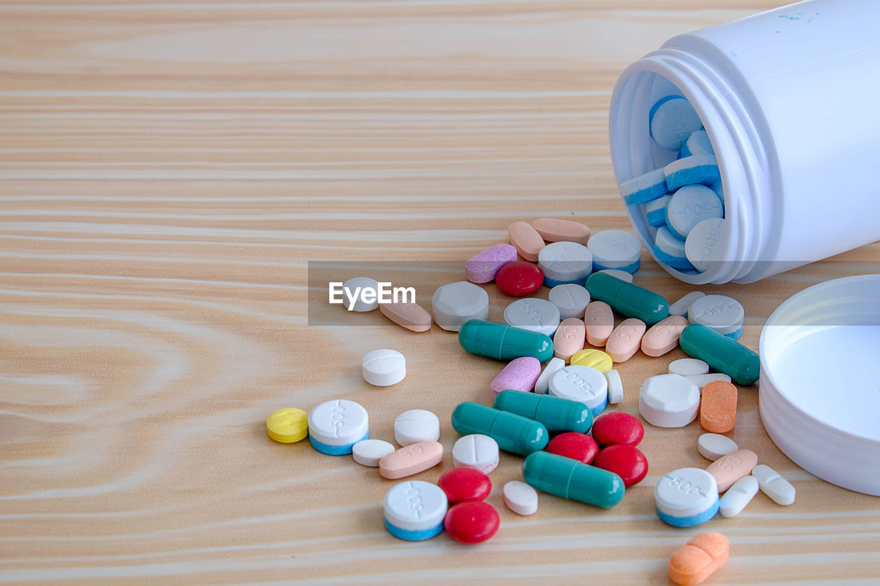 High angle view of pills with container on table