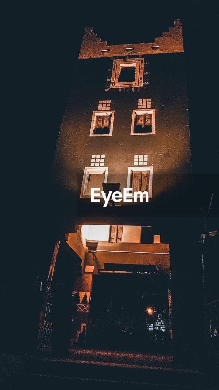 LOW ANGLE VIEW OF ILLUMINATED BUILDING AGAINST SKY