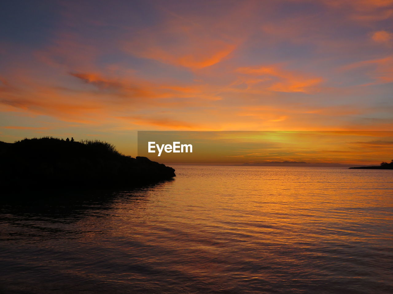 Scenic view of sea against orange sky