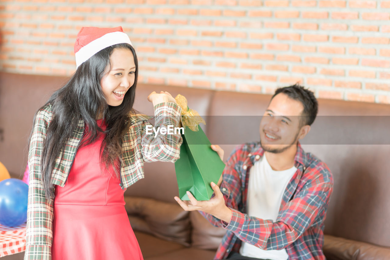 Man giving gift to girlfriend during christmas party