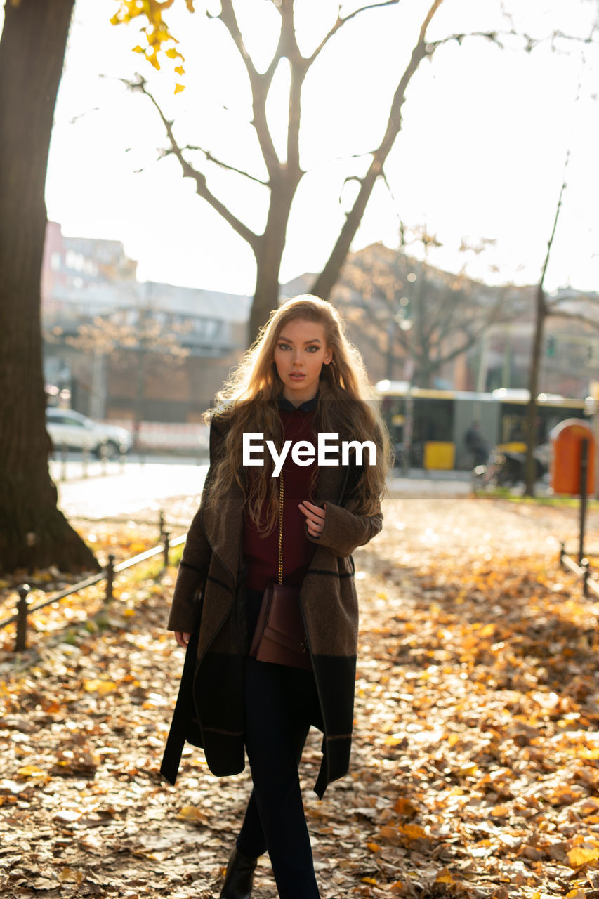 Portrait of young woman standing in autumn