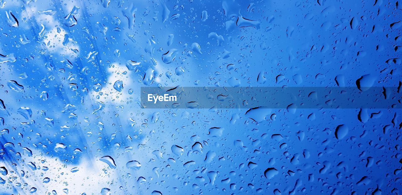 FULL FRAME SHOT OF RAINDROPS ON GLASS WINDOW