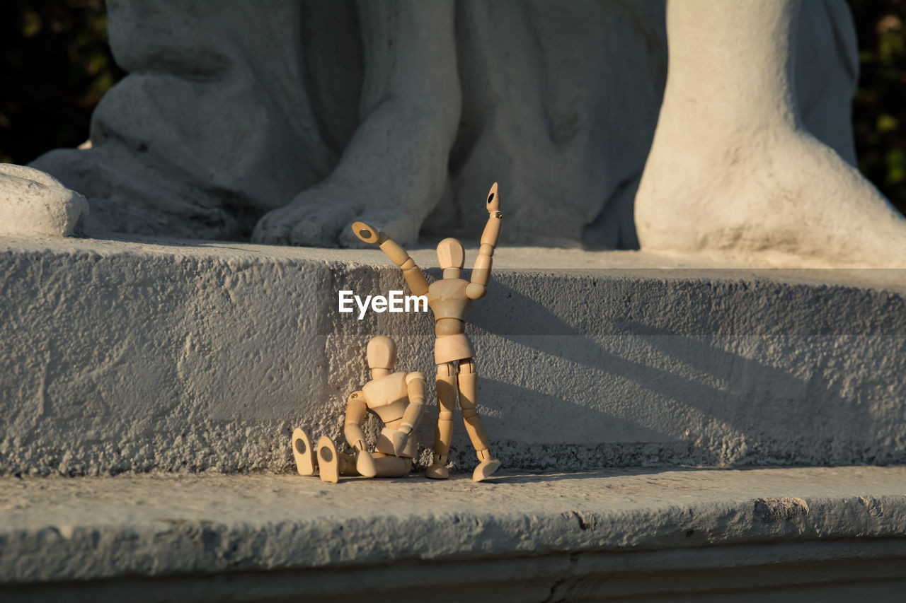 Wooden dolls against statue