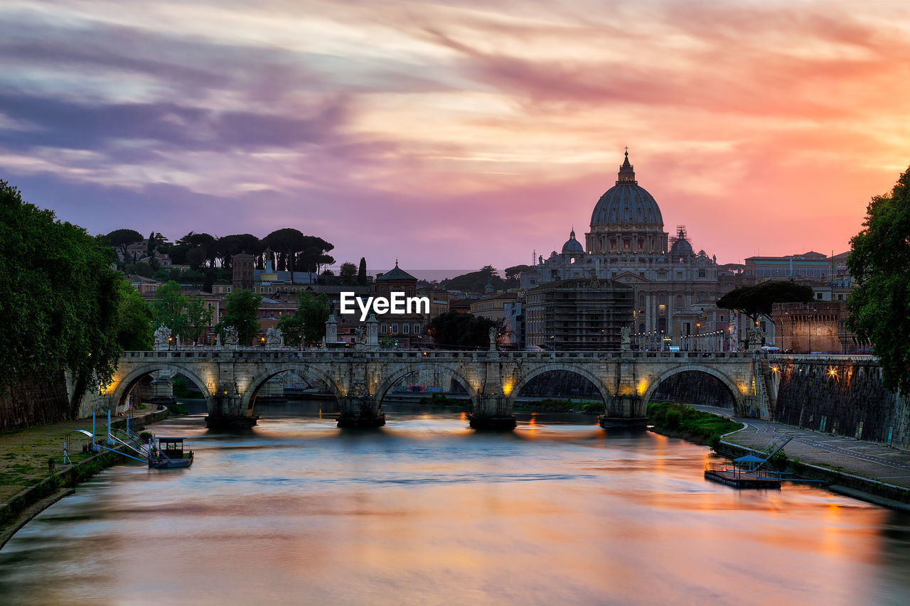 ARCH BRIDGE OVER RIVER IN CITY AGAINST SKY