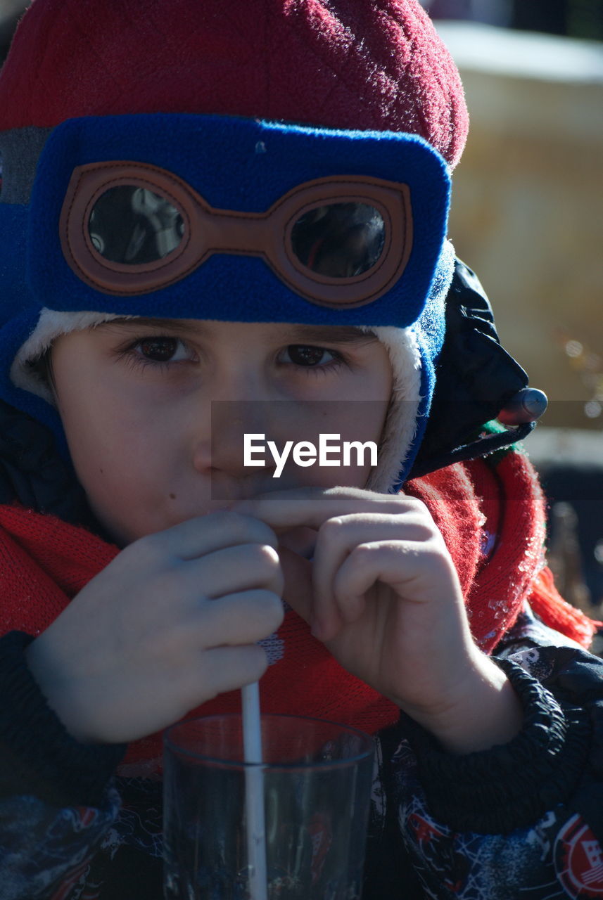 CLOSE-UP PORTRAIT OF BOY DRINKING IN SNOW