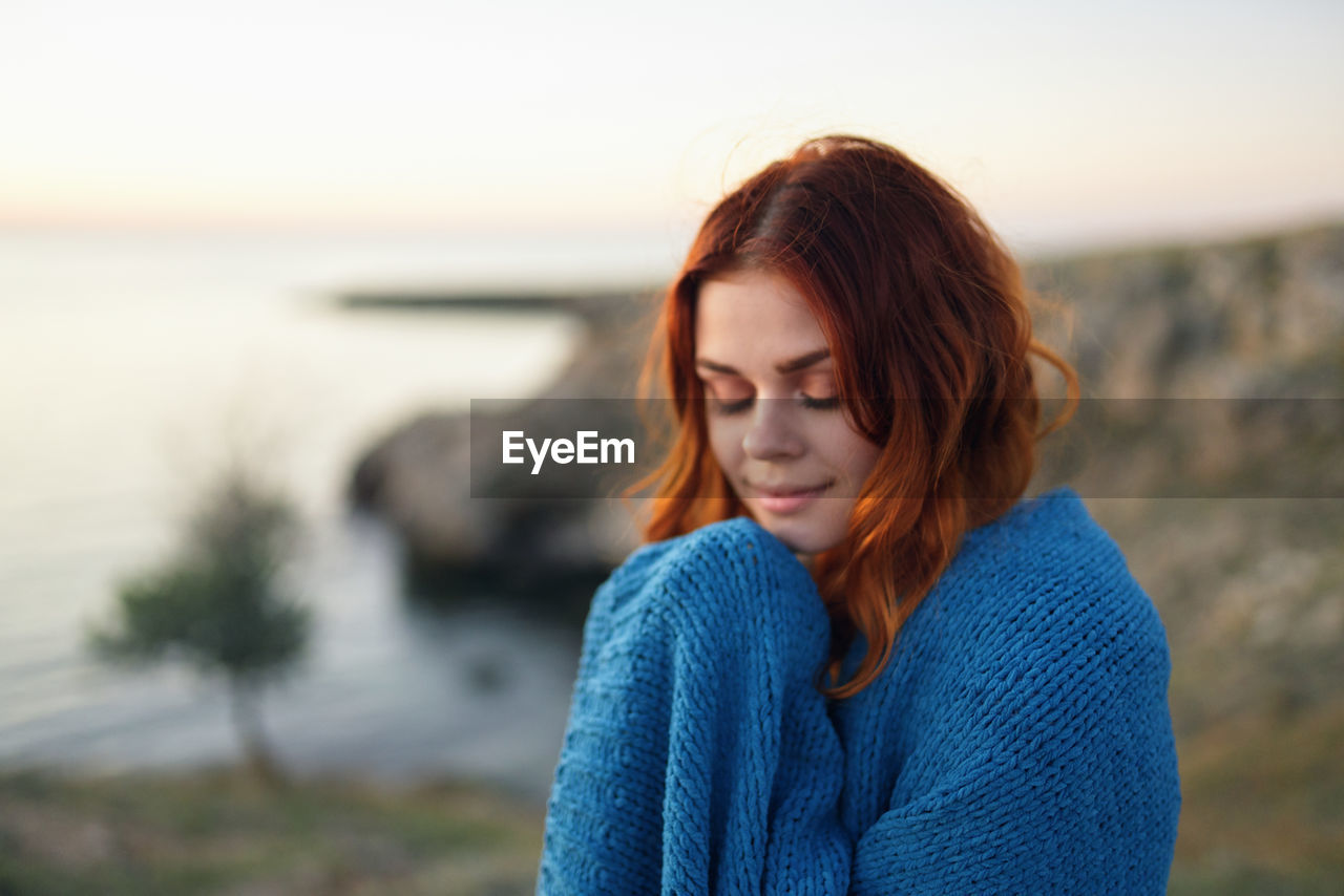 BEAUTIFUL YOUNG WOMAN LOOKING AT SEA SHORE