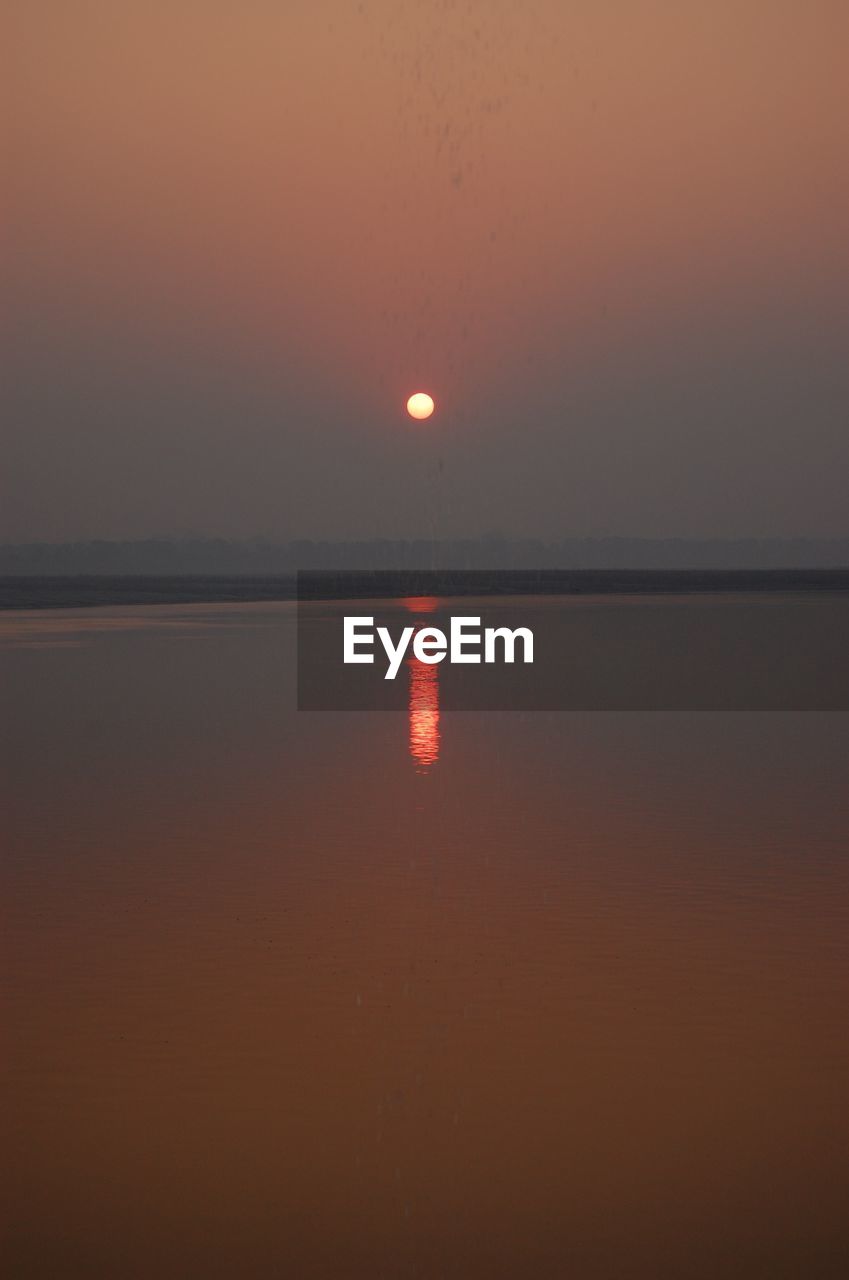 SCENIC VIEW OF SEA AGAINST ORANGE SKY DURING SUNSET