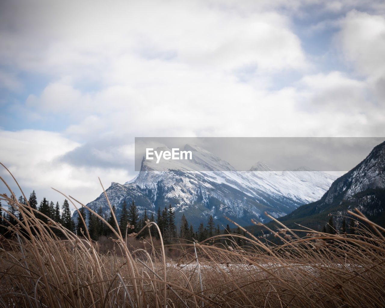 Snowy mountain mount rundle covered by snow and shrouded by clouds, banff national park, canada