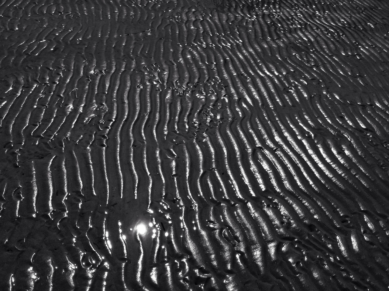 High angle view of wet sand with wave pattern