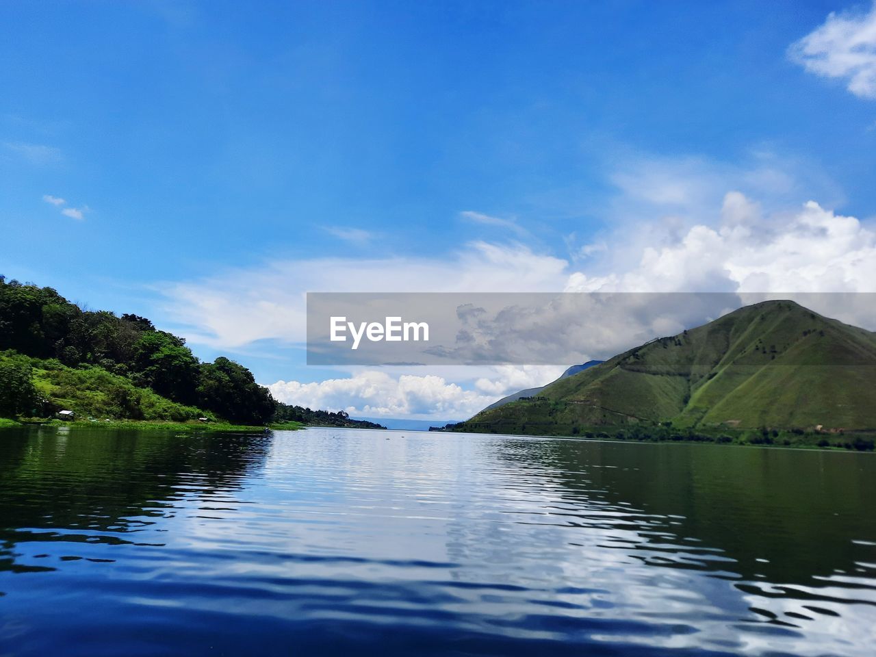 Scenic view of lake by mountains against sky