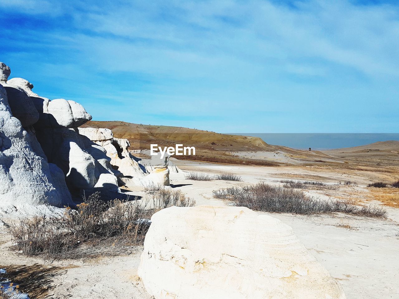 Scenic view of rocky shore against sky