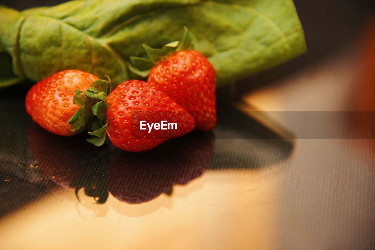 CLOSE-UP OF STRAWBERRIES ON TABLE