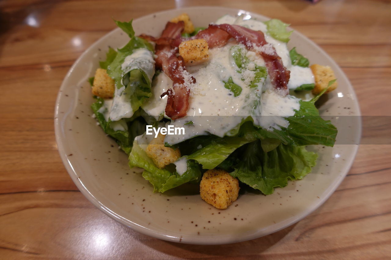 food and drink, food, healthy eating, salad, wellbeing, vegetable, freshness, meal, dish, plate, table, indoors, caesar salad, no people, fast food, produce, lunch, close-up, wood, high angle view, serving size, cuisine, breakfast, meat