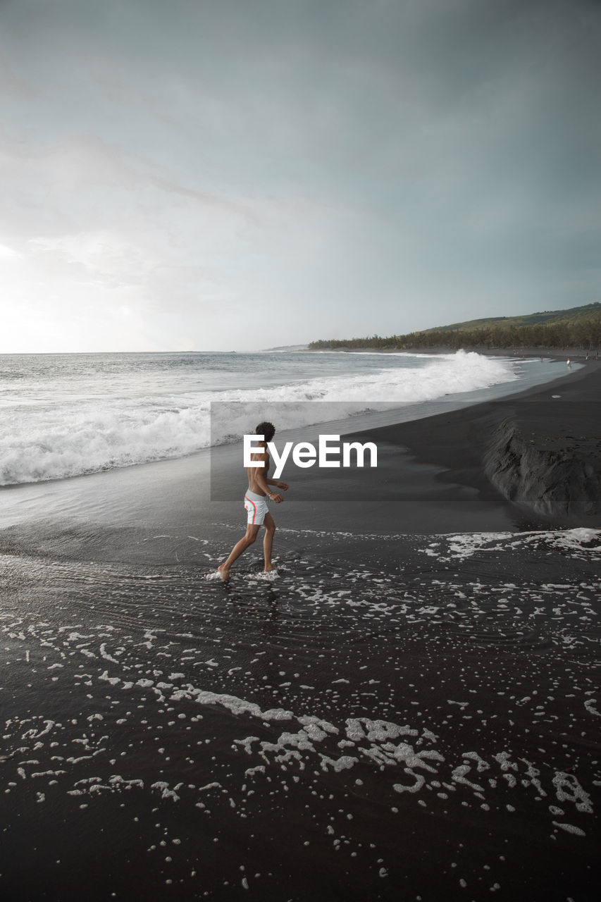 Full length of man walking on shore at beach