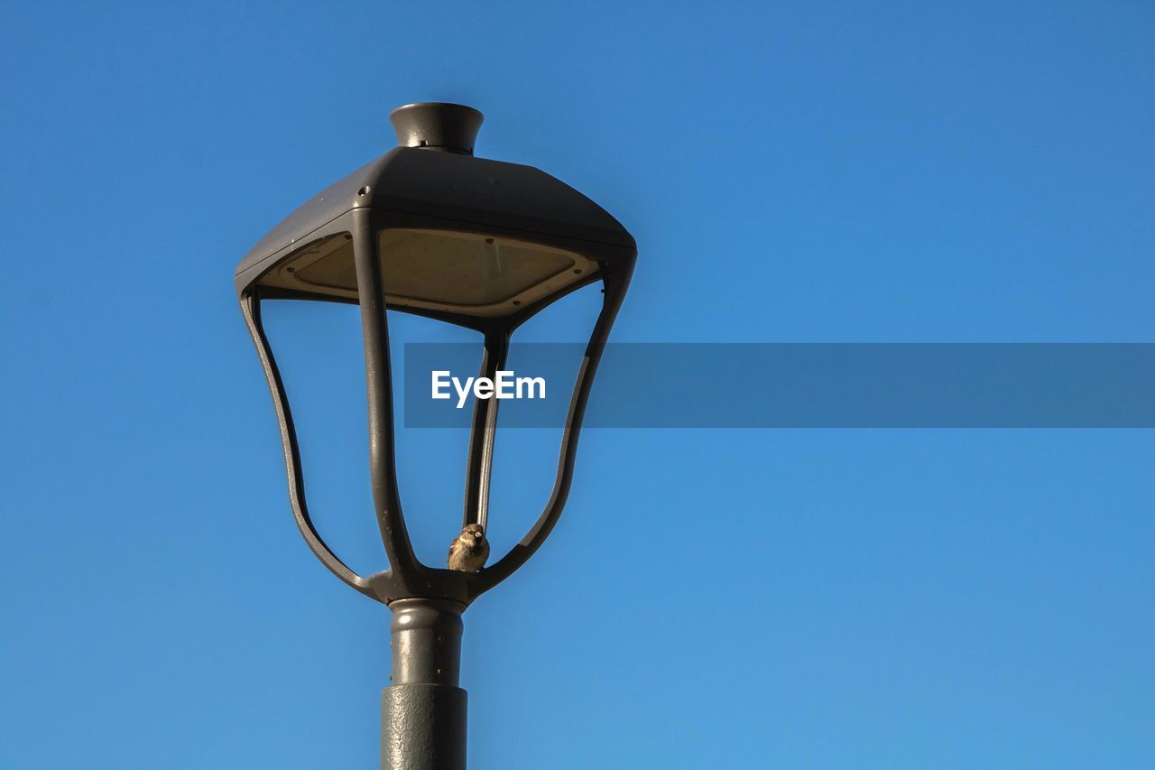 Low angle view of street light against clear blue sky