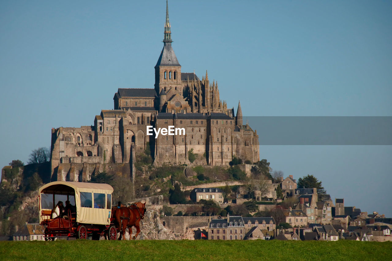 Horse carriage and castle against blue sky