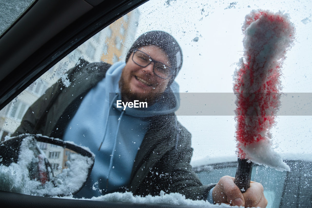 side view of young man with water in car