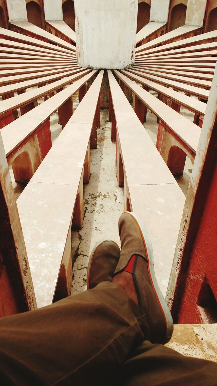 LOW SECTION OF MAN STANDING ON METAL FLOOR