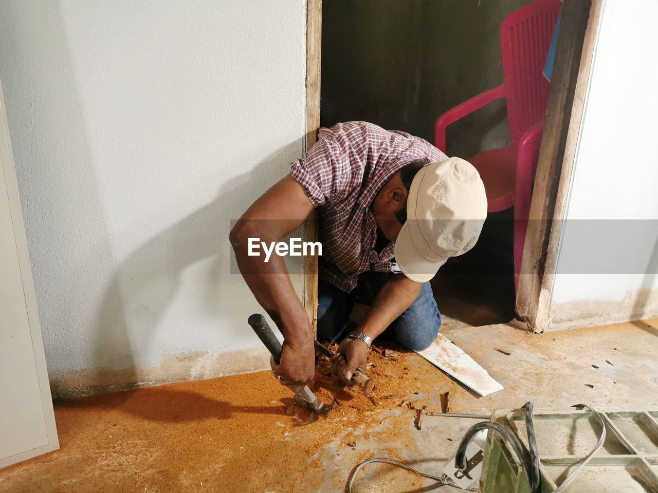 HIGH ANGLE VIEW OF MAN WORKING AT HOME AGAINST WALL