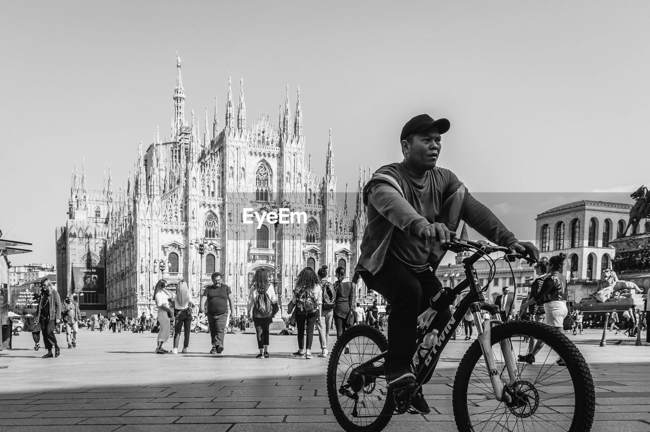 MAN RIDING BICYCLES ON CITY