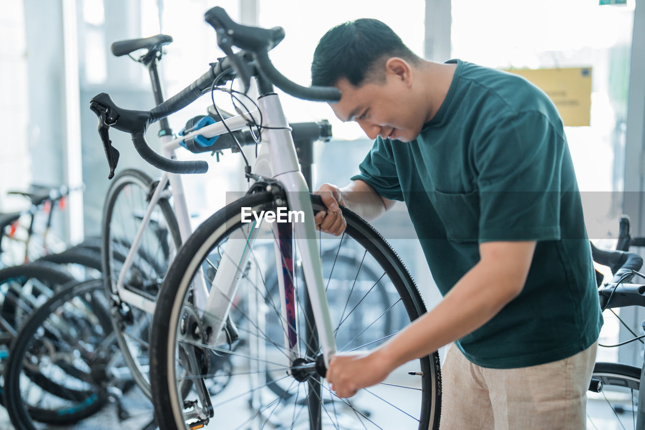 side view of man repairing bicycle