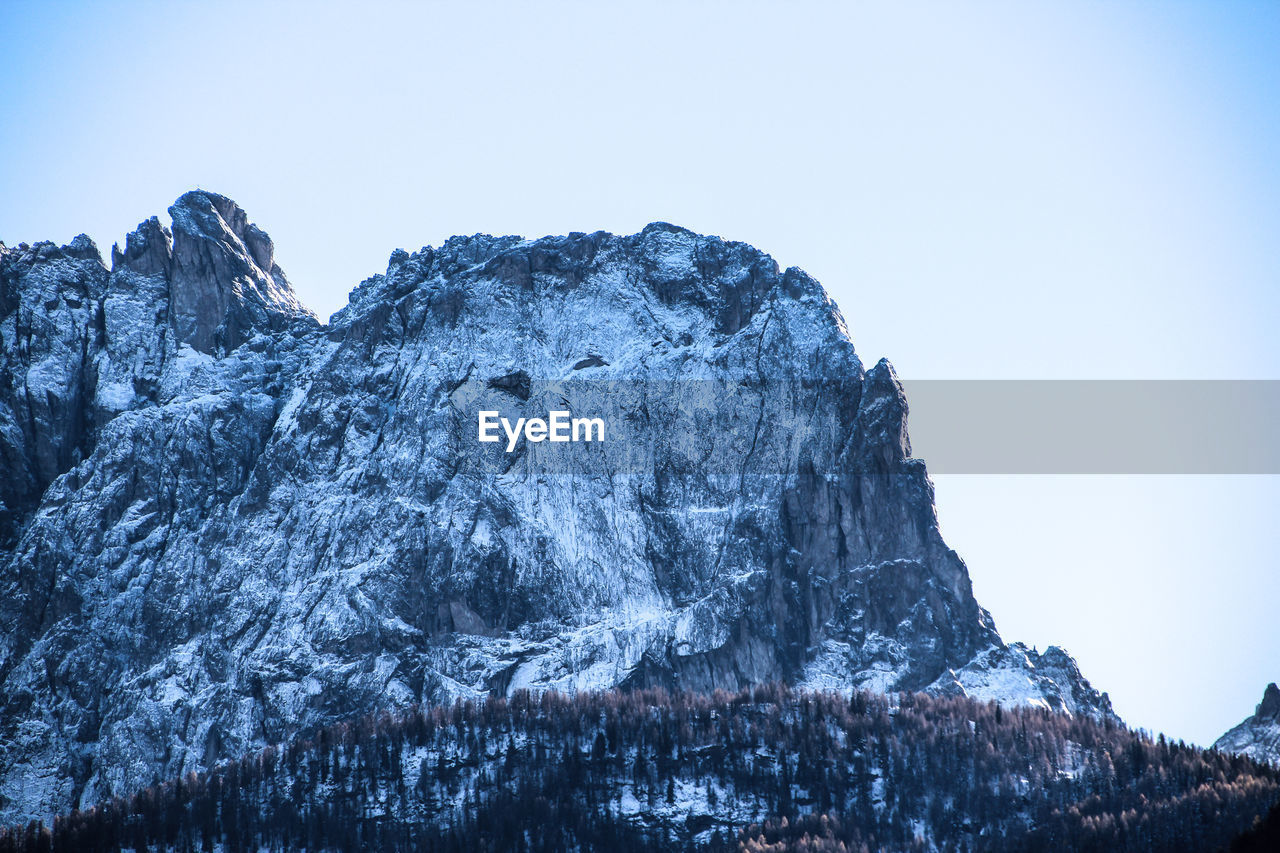 Low angle view of frozen mountain against clear sky