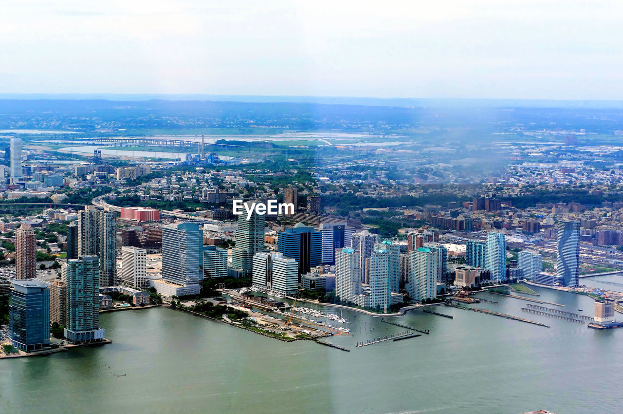 High angle view of city by river against sky