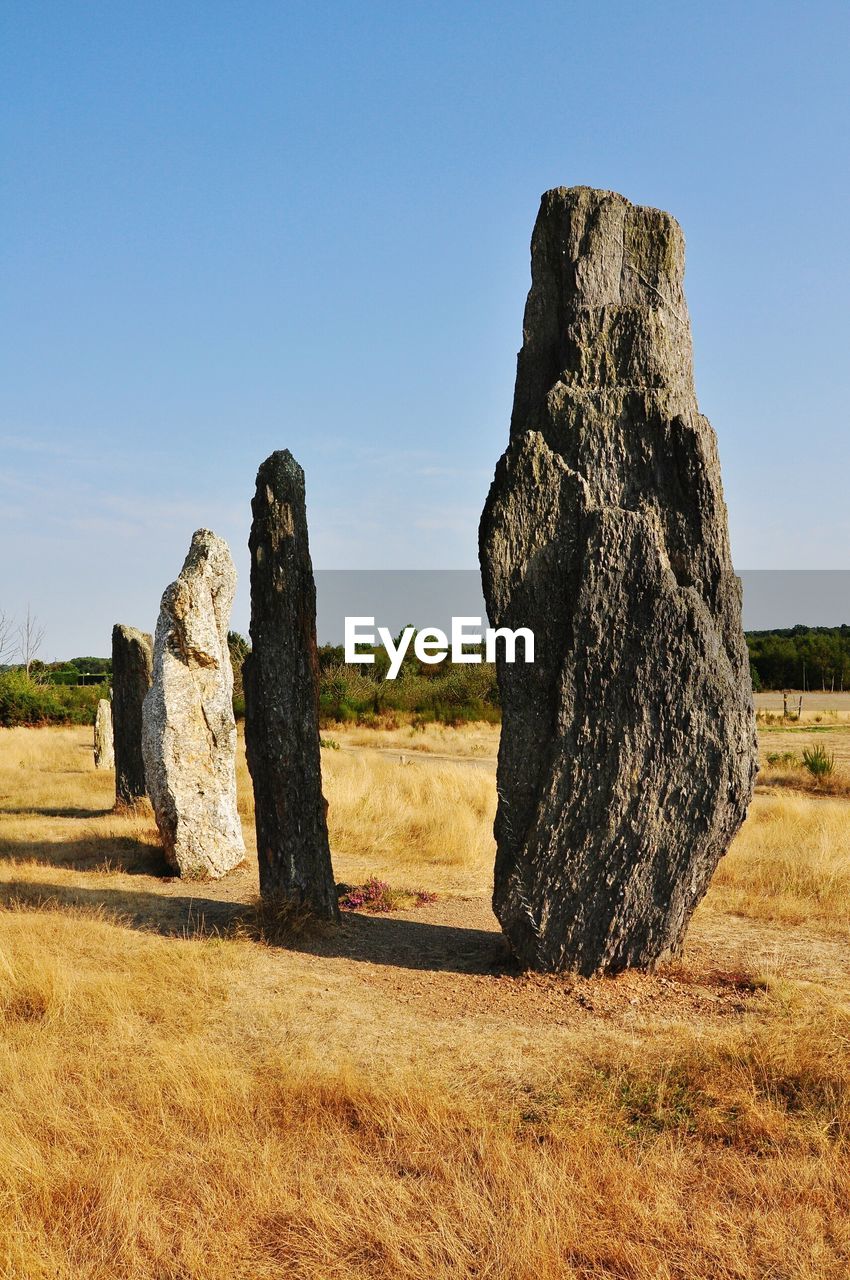 Hay bales on field against clear sky