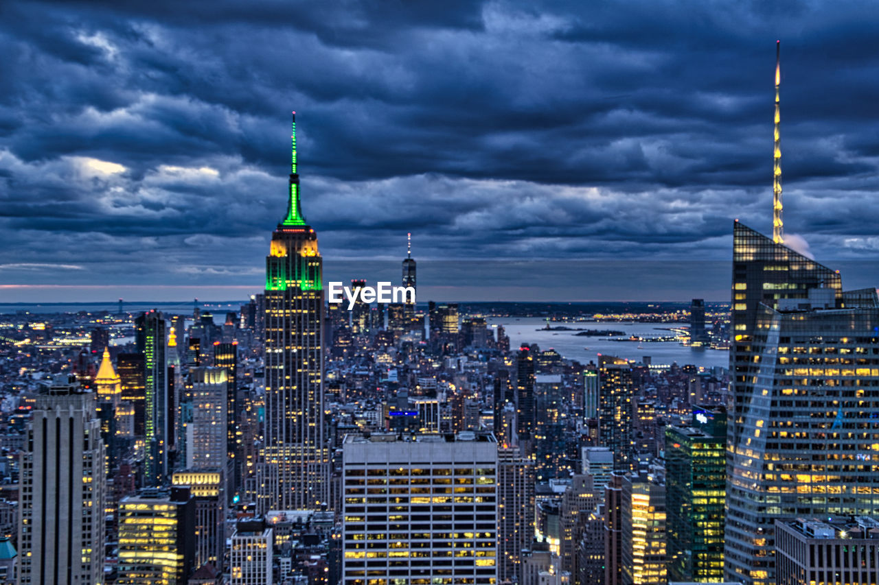 Illuminated buildings in city against cloudy sky manhattan downtown