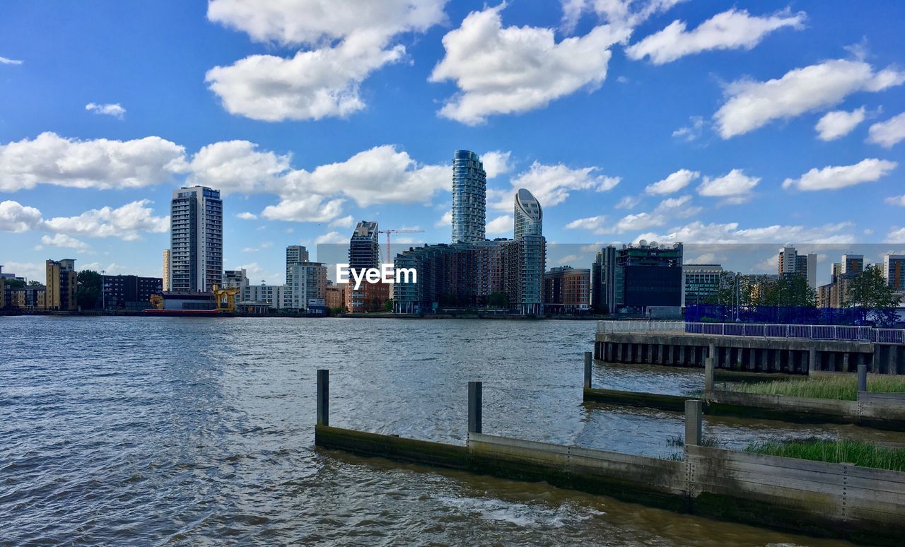 River in city against cloudy sky