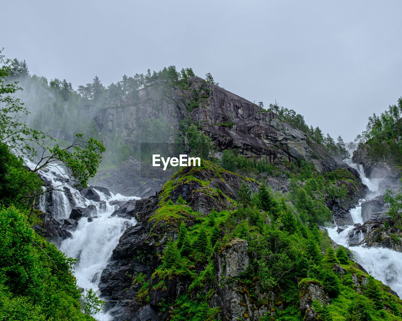 Scenic view of waterfall against sky