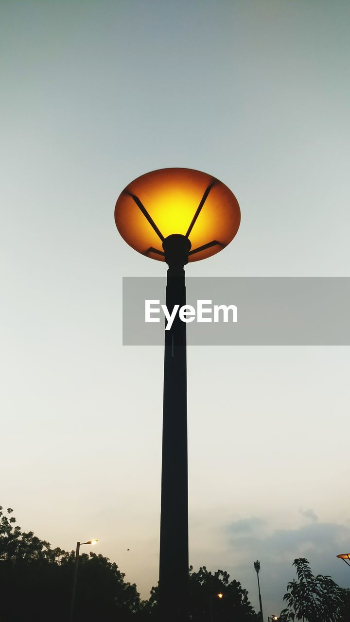 Low angle view of illuminated tree against clear sky at sunset