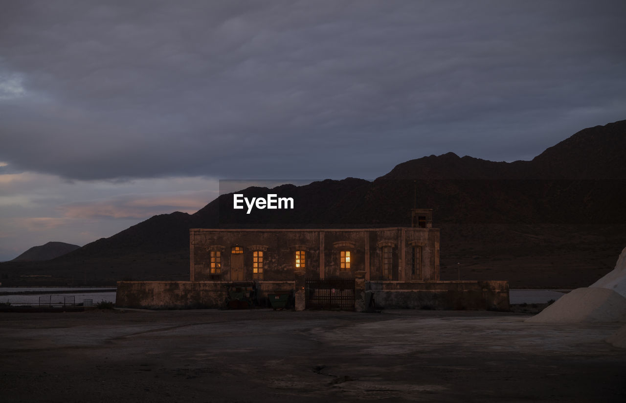 Sea salt factory building at night against mountains. las salinas, cabo de gata, almeria, spain