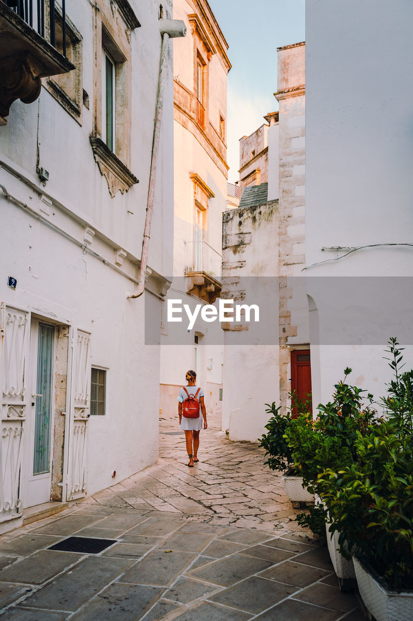 Girl walking through the alleys of the historic center of martina franca