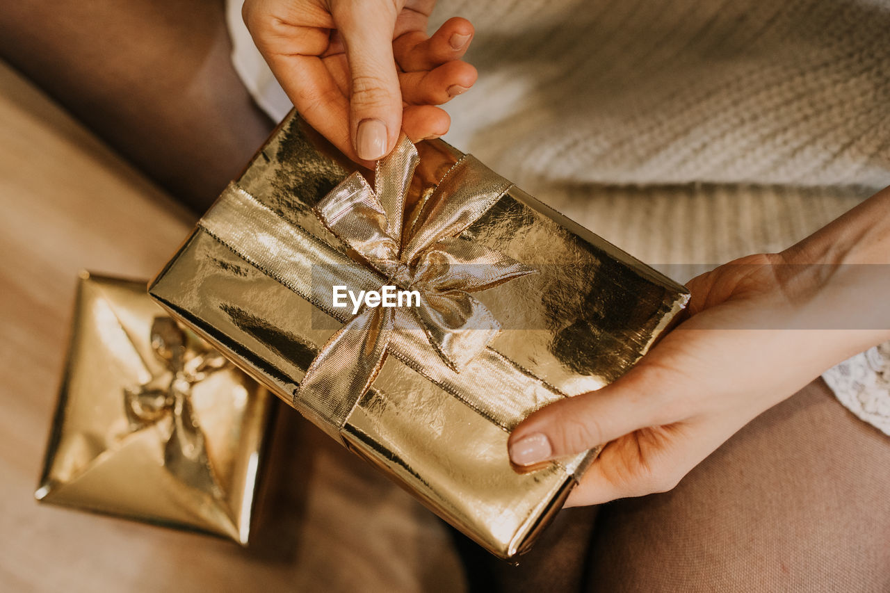 Midsection of woman opening gift