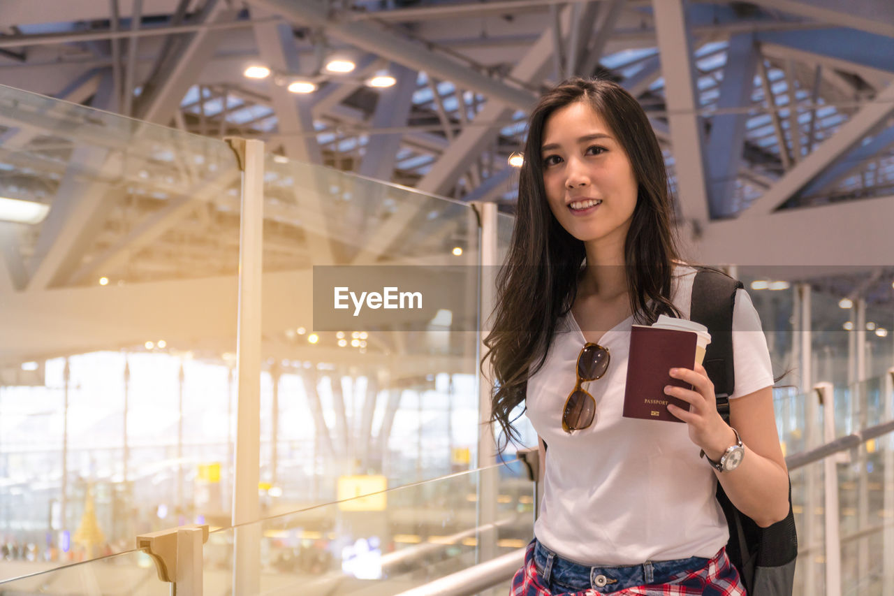 Portrait of smiling young woman standing at airport