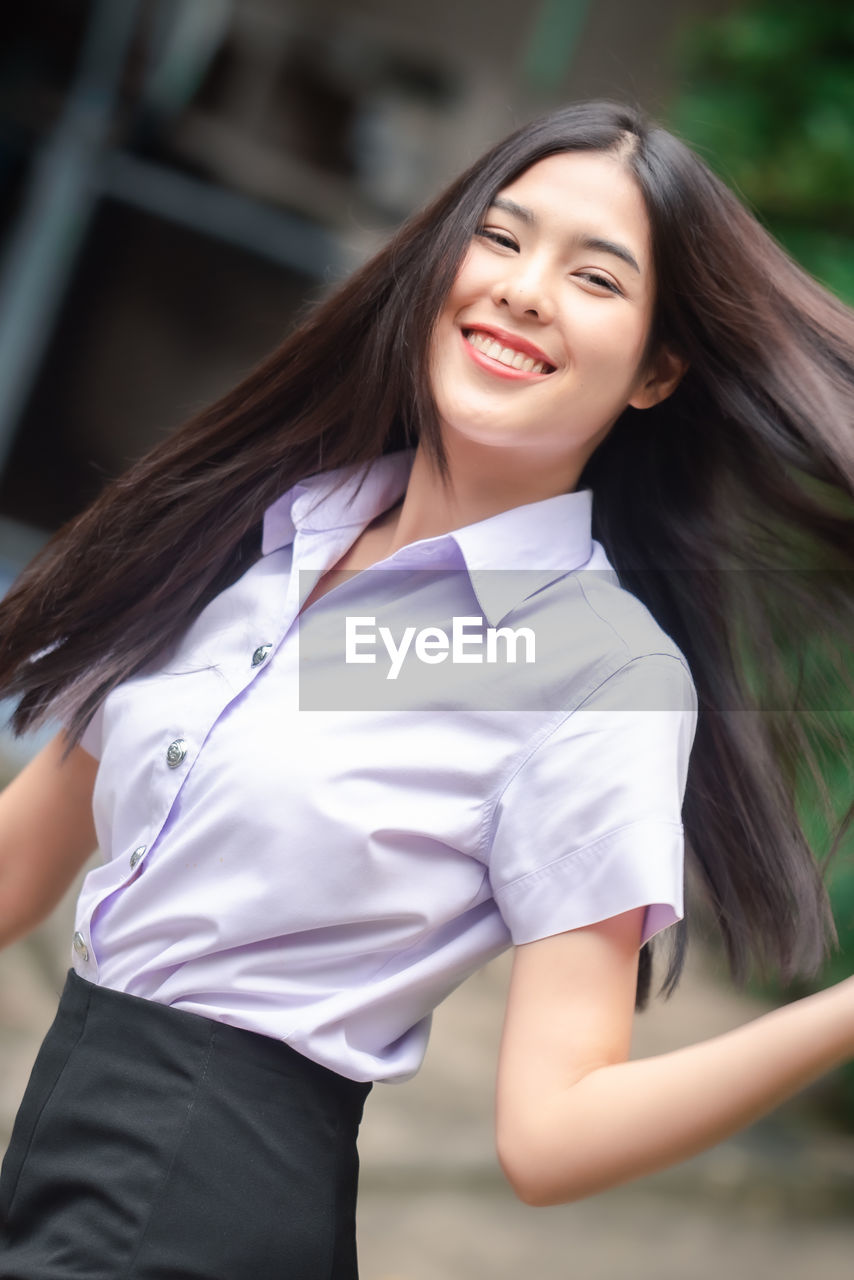 PORTRAIT OF A SMILING YOUNG WOMAN WITH HAIR FACE