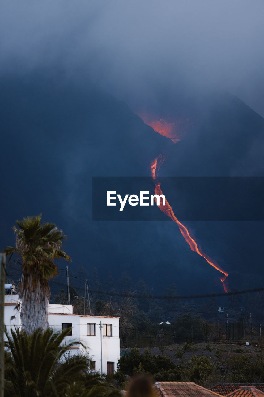 Hot lava and magma pouring out of the crater with black plumes of smoke. cumbre vieja volcanic eruption in la palma canary islands, spain, 2021