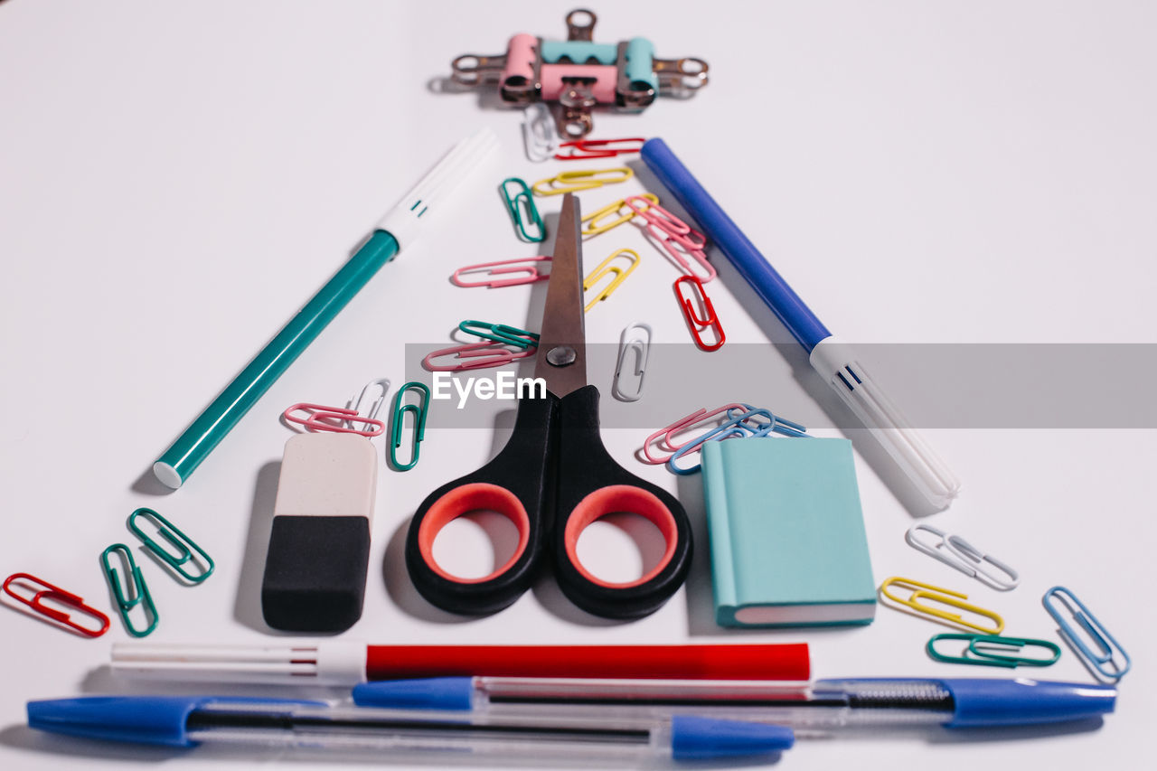 HIGH ANGLE VIEW OF COLORED PENCILS ON TABLE AGAINST WHITE BACKGROUND