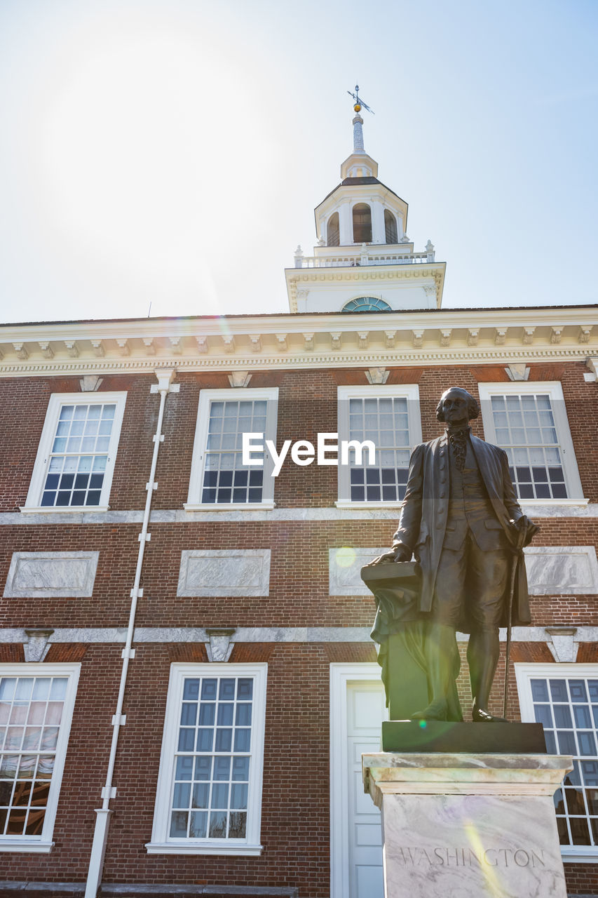 LOW ANGLE VIEW OF STATUE AGAINST BUILDING AND SKY