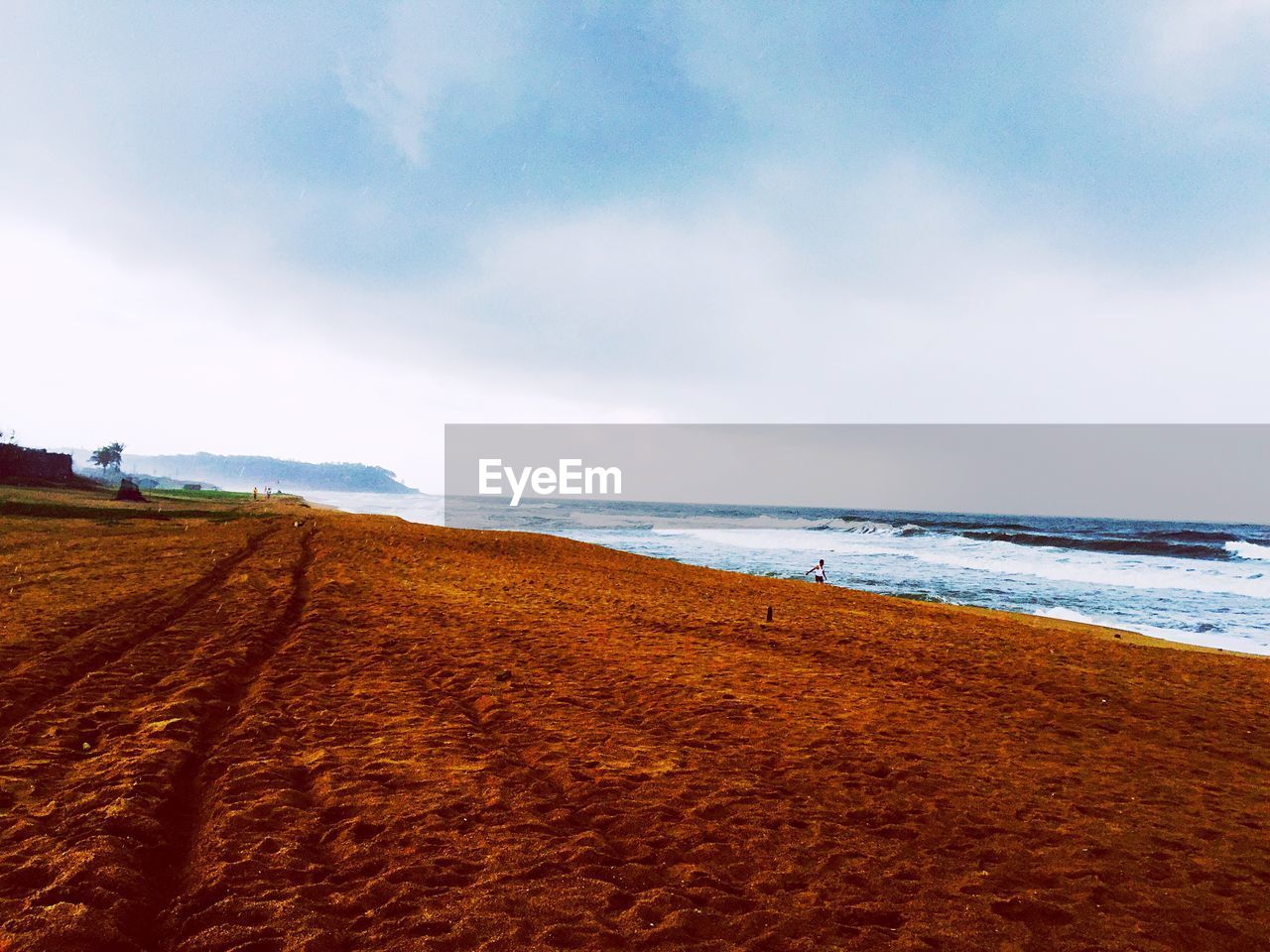 Barren field along calm blue sea