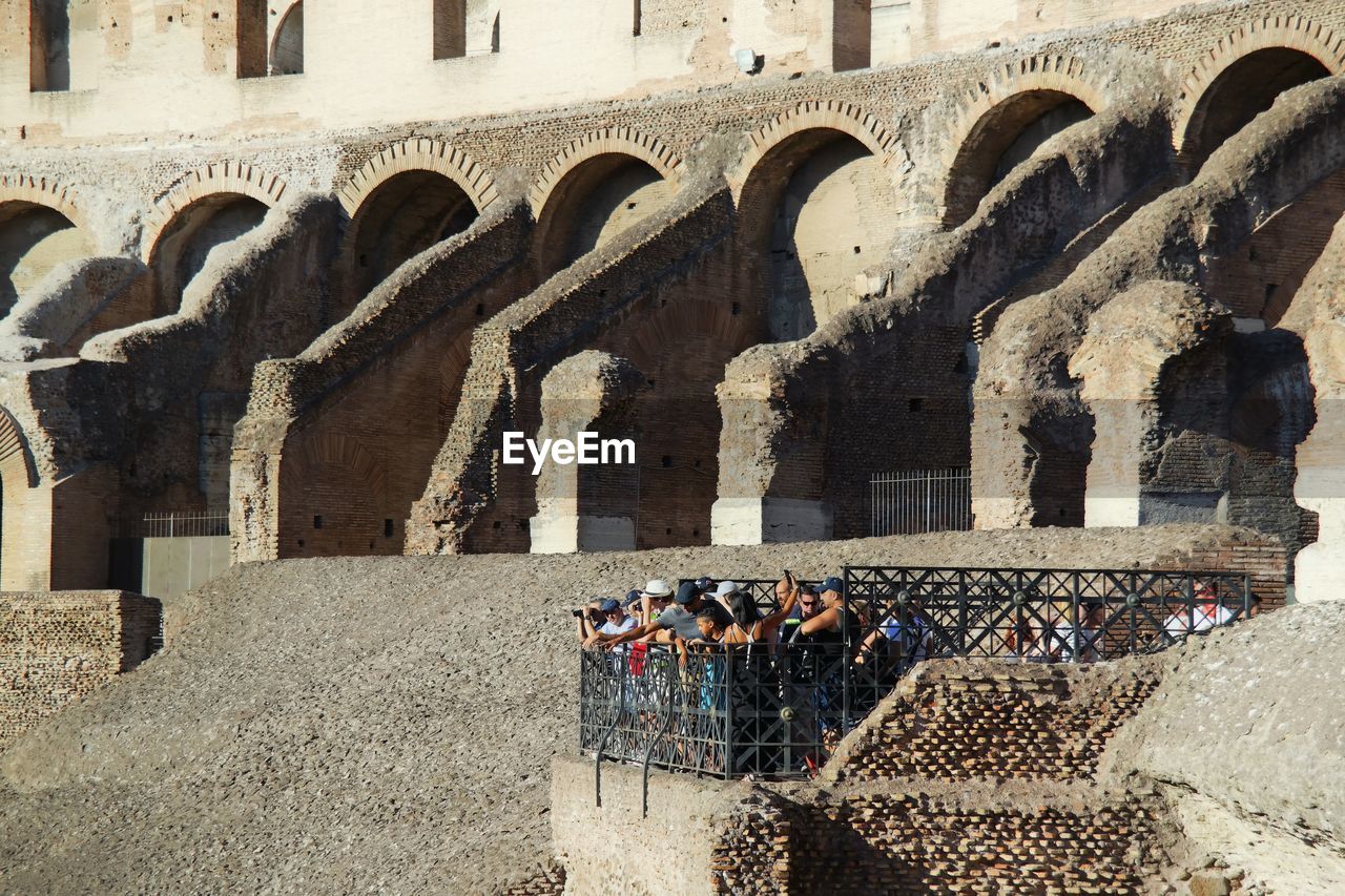 People standing against historic building