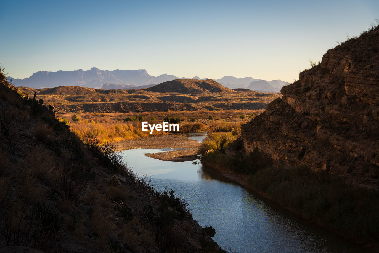 Scenic view of lake and mountains against clear sky