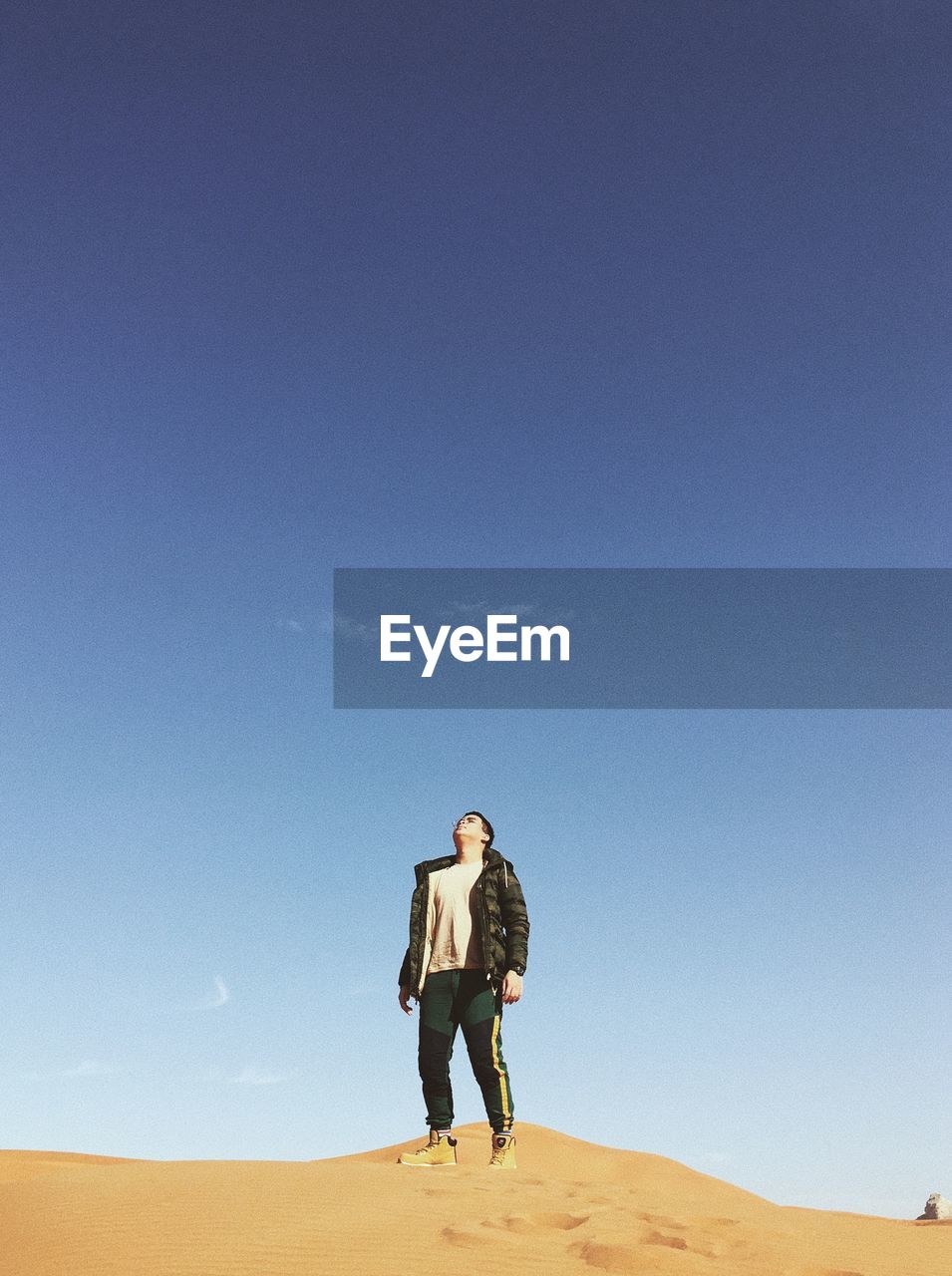 FULL LENGTH OF YOUNG WOMAN STANDING ON DESERT