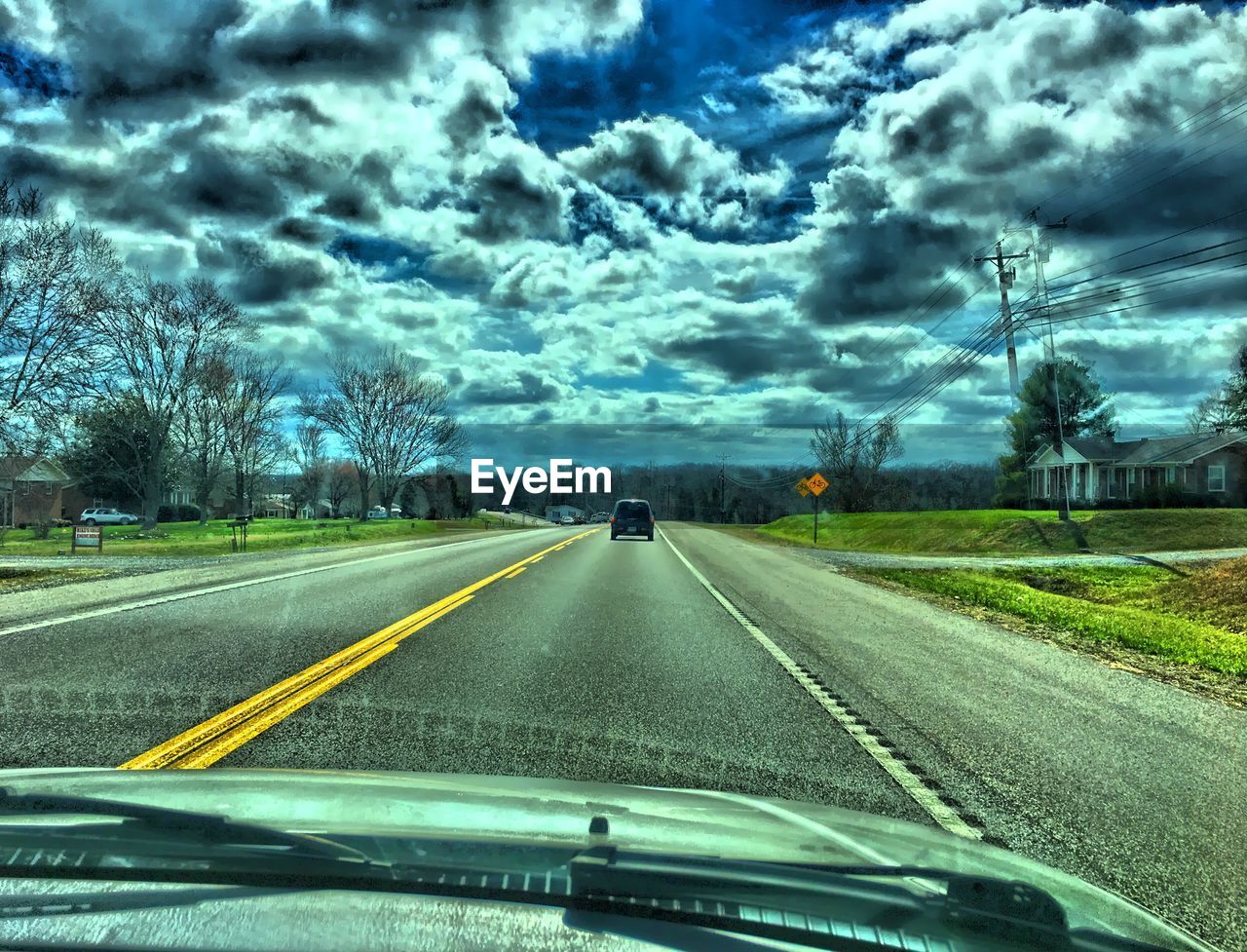 ROAD SEEN THROUGH WINDSHIELD OF CAR