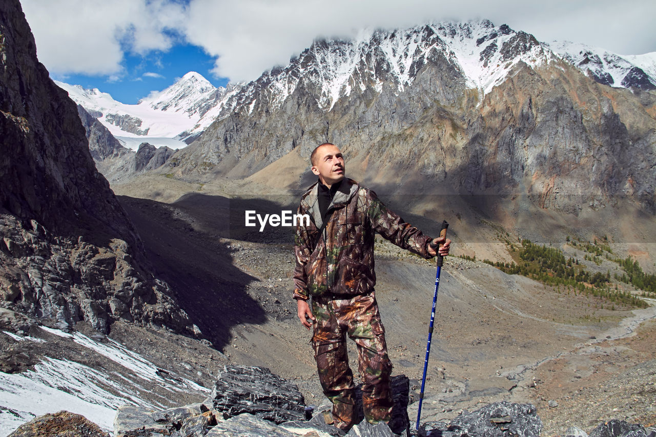 Young woman standing on snowcapped mountains during winter