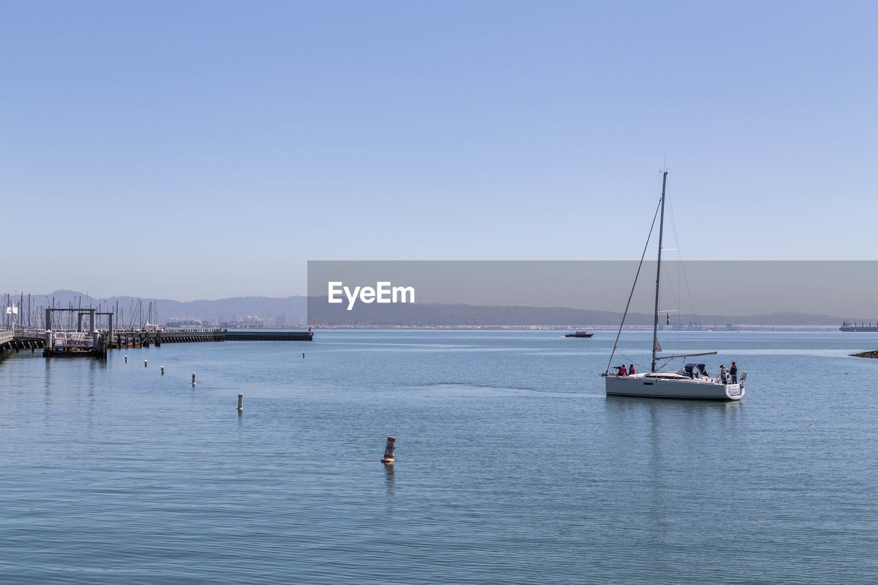 SAILBOAT IN SEA AGAINST CLEAR SKY